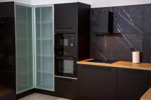 a kitchen with black appliances and a glass cabinet at Elea resort in Preveza