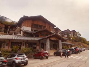 un grande edificio con auto parcheggiate in un parcheggio di Bel appartement en résidence avec piscine a Orelle