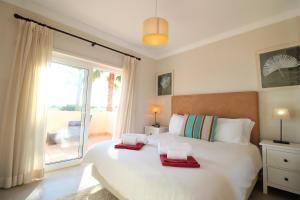 a bedroom with a large bed with two red towels on it at Quinta da Atalaia in Lagos