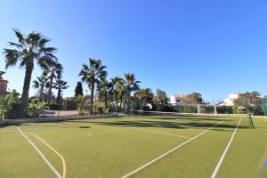 una pista de tenis con palmeras al fondo en Quinta da Atalaia en Lagos