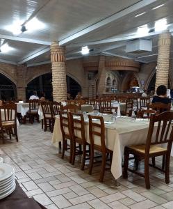 uma sala de jantar com mesas e cadeiras num restaurante em La Rustica Hotel em Capo Rizzuto