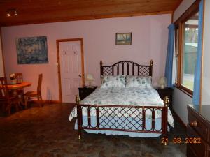 1 dormitorio con cama, mesa y ventana en Self-contained Cabin 10 min to Huskisson en Tomerong