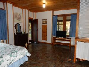 1 dormitorio con 1 cama y escritorio con TV en Self-contained Cabin 10 min to Huskisson en Tomerong