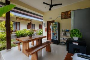a dining room with a wooden table and bench at BUBU CANGGU Guesthouse in Canggu
