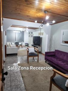 Casa Sofía في كونستيتسيون: غرفة معيشة مع أريكة أرجوانية وطاولة