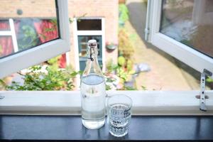 a bottle and two glasses sitting on a window sill at Hello I'm Local - Boutique Hostel in Haarlem