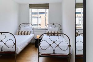 two beds in a room with a window at Hello I'm Local - Boutique Hostel in Haarlem