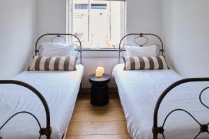 two twin beds in a room with a window at Hello I'm Local - Boutique Hostel in Haarlem