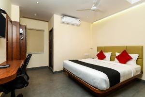 a hotel room with a bed and a desk and a desk at Super Capital O Hotel Siddartha Grand in Mohammadnagar