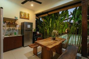 a kitchen with a wooden table and a balcony at BUBU CANGGU Guesthouse in Canggu