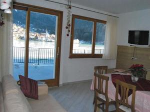 a living room with a table and a view of the water at Appartamenti Chalet al Lago in Alleghe