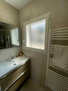 uma casa de banho com um lavatório e uma janela em Carry le Rouet : superbe T2 neuf em Carry-le-Rouet