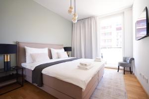 een witte slaapkamer met een groot bed en een raam bij Exclusive 2-Bedroom condo with Pool & Balcony in Wenen