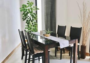 a dining room with a table with black chairs at BODU ASHI MALDIVES - Central 3 Bedroom Apartment in Hulhumale