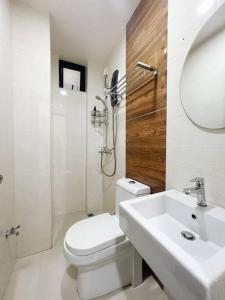 a white bathroom with a toilet and a sink at BODU ASHI MALDIVES - Central 3 Bedroom Apartment in Hulhumale
