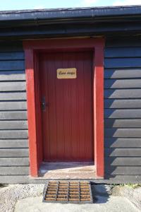 Eine rote Tür mit einem Schild, auf dem steht: in der Unterkunft Høvringen Fjellstue in Høvringen