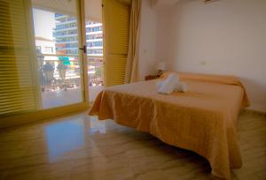 um quarto com uma cama e uma grande janela em Puerta del Sol TRM only adults Aparts em Torremolinos