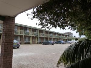 a building with cars parked in a parking lot at Wintersun Motel in Victor Harbor