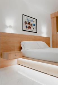 雅典的住宿－Luxury Studio in the heart of Kolonaki，卧室配有白色的床和木制床头板