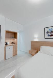 雅典的住宿－Luxury Studio in the heart of Kolonaki，一间白色卧室,配有床和厨房