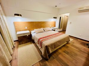 a bedroom with a large bed with a wooden headboard at Sabe Center in Asunción