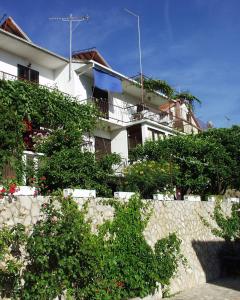 a white building with a fence in front of it at Rooms by the sea Jelsa, Hvar - 127 in Jelsa