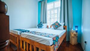 2 camas individuales en una habitación con ventana en Villa Passiflora Zanzibar en Jambiani