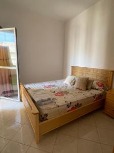um quarto com uma cama de madeira num quarto em PROMO Appartement Familial avec WiFi em Al Hoceïma