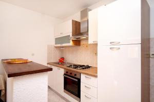 a kitchen with white cabinets and a stove top oven at Apartments by the sea Sveta Nedilja, Hvar - 110 in Sveta Nedelja