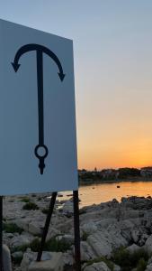 a sign on the shore of a body of water at Apartmani Sirius in Silba