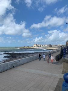 um grupo de pessoas caminhando ao longo da praia em Phoenix caravan hire, Trecco bay em Porthcawl