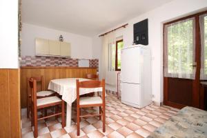 La cuisine est équipée d'une table, de chaises et d'un réfrigérateur. dans l'établissement Apartments by the sea Mudri Dolac, Hvar - 118, à Vrboska