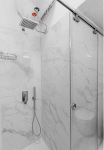 uma casa de banho com um chuveiro e uma porta de vidro em Luxury Studio in the heart of Kolonaki em Atenas