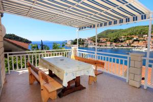 a patio with a table and benches on a balcony at Apartments by the sea Brna, Korcula - 147 in Smokvica