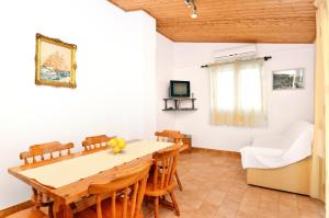 a dining room with a table and chairs and a couch at Apartments by the sea Prizba, Korcula - 149 in Prizba