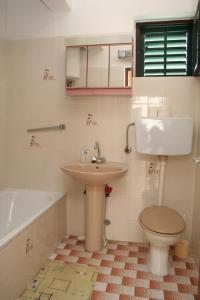 a bathroom with a sink and a toilet and a tub at Apartment Sucuraj 136b in Sućuraj