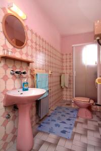 La salle de bains est pourvue d'un lavabo rose et de toilettes. dans l'établissement Apartments by the sea Vrboska (Hvar) - 104, à Vrboska