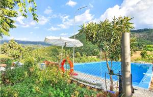 a swimming pool with an umbrella next to at Awesome Home In Orgosolo With Private Swimming Pool, Can Be Inside Or Outside in Orgosolo