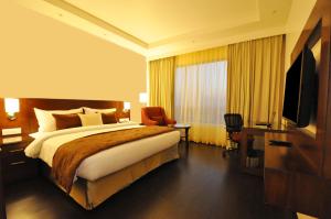 een hotelkamer met een bed en een televisie bij Hotel Marigold Jaipur in Jaipur