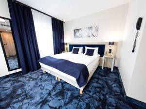 a bedroom with a large bed and a large window at Ignasiak Hotel in Września