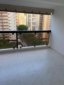 a balcony with a view of a city at NOVO pitangueiras service 2, dois dormitórios, 100 m da praia, duas vagas de garagem, completo in Guarujá