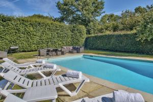 a pool with two lounge chairs and a swimming pool at Timberley Farm by Group Retreats in Pulborough