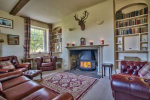 a living room with leather furniture and a fireplace at Timberley Farm by Group Retreats in Pulborough