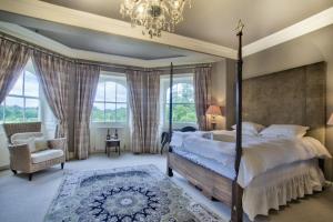 a bedroom with a large bed and a chandelier at The Castle By Group Retreats in Hartlepool