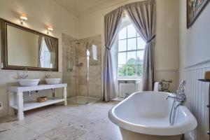 a bathroom with two sinks and a tub and a mirror at The Castle By Group Retreats in Hartlepool