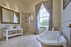 bagno con 2 lavandini, vasca e specchio di The Castle By Group Retreats a Hartlepool