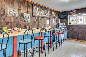 um bar com bancos num restaurante com paredes de madeira em Le Saint Alex em Saint-Alexis-des-Monts