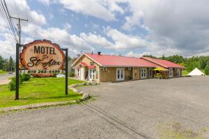 a motel with a sign in front of a building at Le Saint Alex in Saint-Alexis-des-Monts