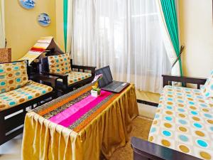a room with two beds and a laptop on a table at OYO LIFE 91551 Gwen Syariah Homestay in Malang