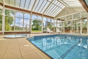 een binnenzwembad in een huis met een glazen plafond bij Milton House Group Retreats in Bedford